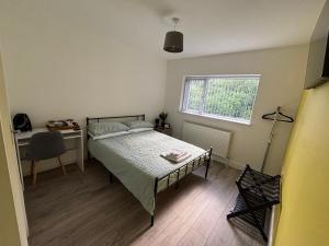 a bedroom with a bed and a desk and a window at Kane's Place in Birkenhead