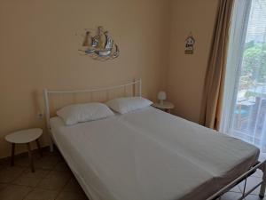 a bed in a bedroom with a large window at Seaside villa in Eretria in Eretria