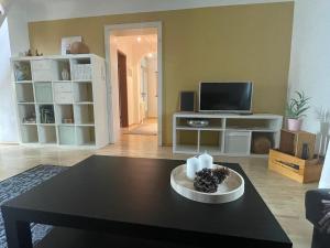 a living room with a table and a tv at Gemütliche Ferienwohnung zwischen Europa-Park und Schwarzwald in Lahr