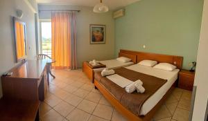 a bedroom with two beds and a desk and a window at Blue escape in Nafplio
