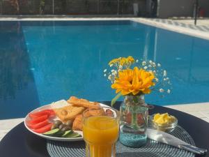 a table with a plate of food and a glass of orange juice at Hotel Sisana in Vlorë