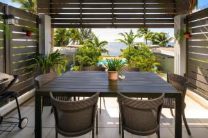 a table on a balcony with a view of the ocean at Plage Bleue D2 in Trou aux Biches
