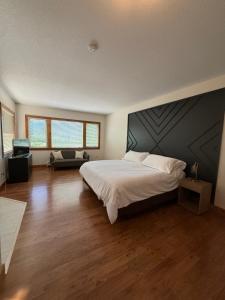 a bedroom with a large bed and a couch at Kiwi Cove Lodge in Ladysmith
