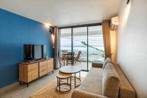 a living room with a couch and a television at La Kaz Amiral in Saint-Pierre