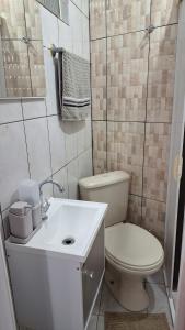 a small bathroom with a toilet and a sink at Minicasa Show! in Jandira