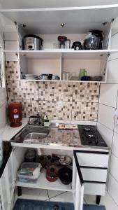 a small kitchen with a sink and a stove at Minicasa Show! in Jandira +8 photos