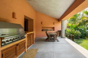 an outdoor kitchen with a stove and a table at Villa La Ceiba in La Huerta