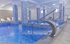 a large swimming pool with blue tiles on the walls at Vila Etikette in Baile Felix