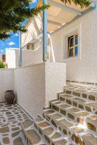 a house with a stone walkway in front of a building at Filoxenia Apartments in Adamantas