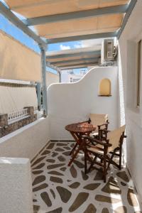 a patio with a table and chairs on a balcony at Filoxenia Apartments in Adamantas