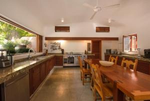 a kitchen with a wooden table and a dining room at Villa La Ceiba in La Huerta