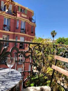 a wine glass sitting on top of a table next to a building at Nice - Stylish apartment downtown in Nice