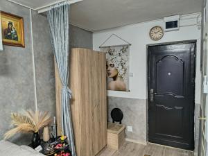 a bedroom with a black door and a clock on the wall at Home MARIA in Orşova