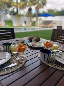 a table with plates of food and glasses of orange juice at Dar El Musc Chambres d'hôtes in Sukrah