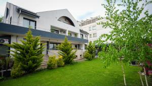 an apartment building with a lawn in front of it at Casa Bendis in Eforie Nord