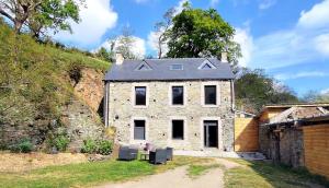 a large stone house with a roof at Le Moulin Hochet in Les Pieux