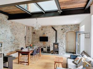 a living room with a table and a fireplace at Le Moulin Hochet in Les Pieux
