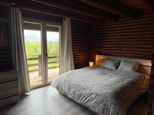 a bedroom with a bed and a large window at Le Caroline du Nord in Tenneville