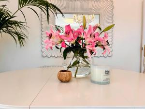 a vase of pink flowers sitting on a table at Apartment with private parking included - Granada in La Zubia
