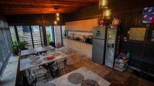 a kitchen with a refrigerator and some tables and chairs at Casa Bendis in Eforie Nord
