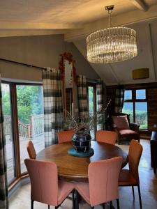 a dining room with a table and chairs and a chandelier at Woodside Lodge, Weybourne, Holt in Weybourne