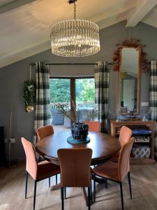 a dining room with a table and chairs and a chandelier at Woodside Lodge, Weybourne, Holt in Weybourne +33 photos