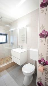 a white bathroom with a toilet and a sink at Casa Bendis in Eforie Nord +56 photos
