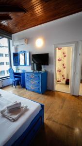 a bedroom with a bed and a blue dresser and a desk at Casa Bendis in Eforie Nord