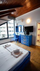 a bedroom with a bed with a blue dresser and a desk at Casa Bendis in Eforie Nord