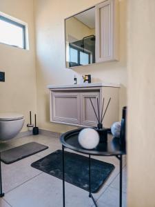 a bathroom with a sink and a mirror at Orang Cottages BW in Ramotswa +6 photos