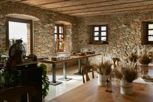 a dining room with a table and a stone wall at Cascina Belvedì in Clanezzo
