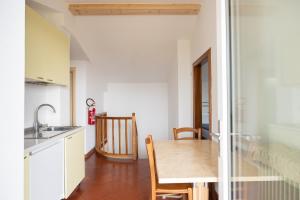 a kitchen with a wooden table and a dining room at Casa Del Noce in Rovereto