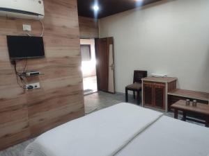 a bedroom with a bed and a tv and a desk at Hotel kabras' inn in Mount Ābu +13 photos