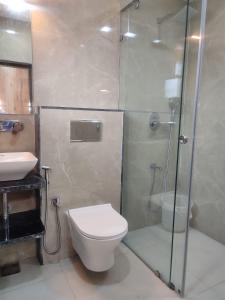 a bathroom with a shower and a toilet and a sink at Hotel kabras' inn in Mount Ābu