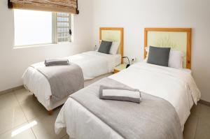 a bedroom with two beds and a window at Ocean Point B3 in Pointe aux Piments +31 photos