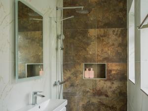 a bathroom with a shower with a sink and a mirror at Harrow Boutique Suites in Harrow +55 photos