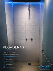 a bathroom stall with a shower with blue lights at Hotel Capsula Condesa in Mexico City