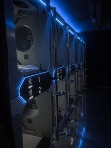 a row of toilets in a row with blue lights at Hotel Capsula Condesa in Mexico City
