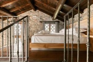 a bedroom with a bed and a stone wall at Cascina Belvedì in Clanezzo