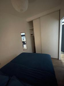 a bedroom with a blue bed and a mirror at Villejuif IGR in Villejuif
