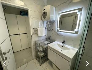 a white bathroom with a sink and a mirror at My Miracle Stinica in Stinica +38 photos