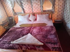 a bedroom with a bed with a purple comforter at Town Front Camping in Leh