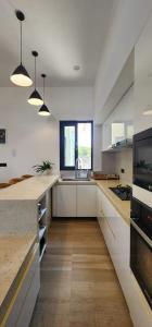 a large kitchen with white counters and a sink at Anona Beachfront Villa in Filadu
