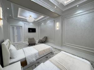 a bedroom with two beds and a chandelier at Samarkand Premium Apartment 1 in Samarkand