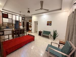 a living room with a red couch and a kitchen at Ira Wanderlust Homes & Tours in Trichūr