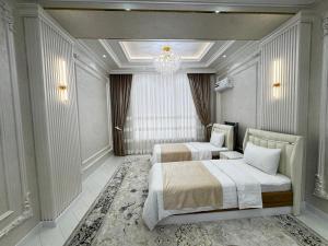 a bedroom with two beds and a chandelier at Samarkand Premium Apartment 1 in Samarkand