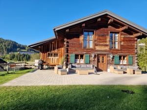 a log house with a patio in front of it at Eberlehof in Riezlern