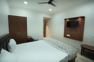 a bedroom with a bed and a tv on the wall at Hotel Chanda in Jhānsi