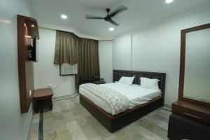 a bedroom with a bed and a flat screen tv at Hotel Chanda in Jhānsi