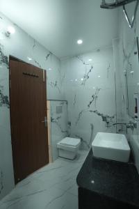 a bathroom with a toilet and a sink at Hotel Chanda in Jhānsi